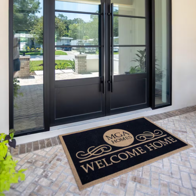 Black doormat with letters MGA on it.