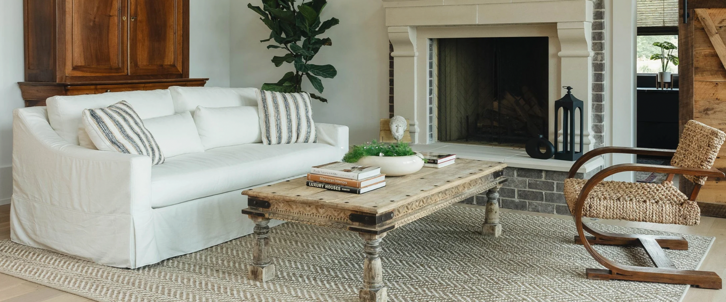 natural grass rug with white couch and wood coffee table sittin on top.