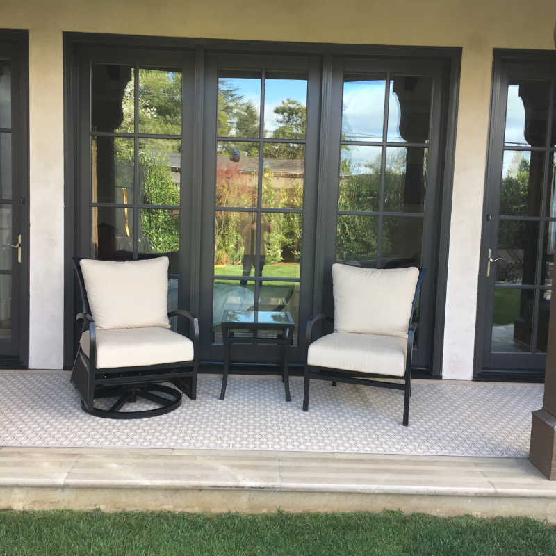 Outdoor area rug with two patio chairs.