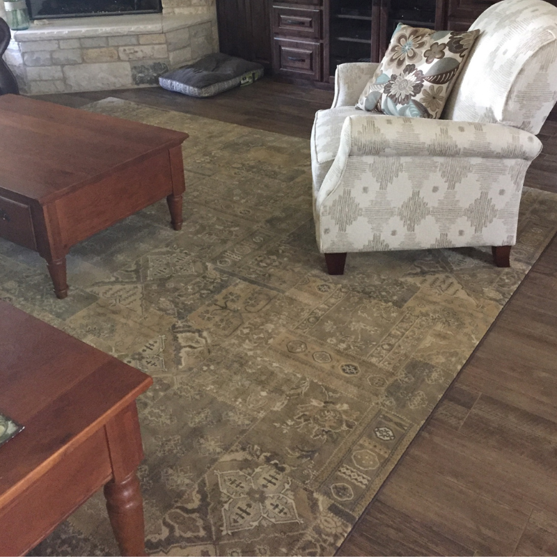 Multi colored beige area rug with white chair.