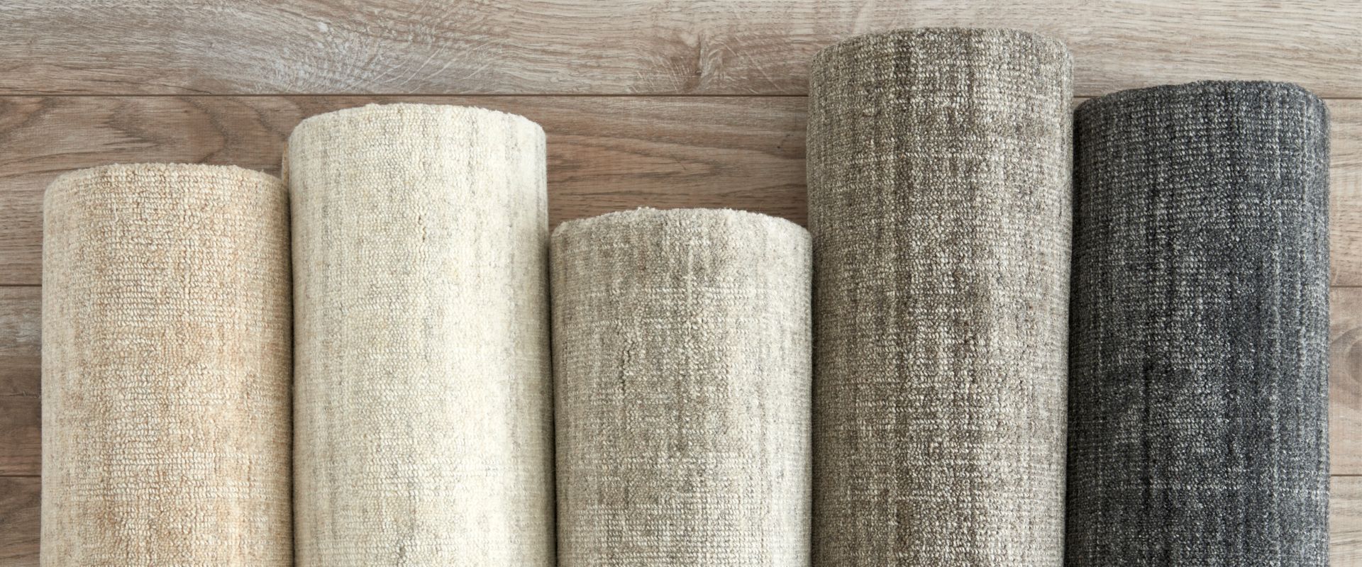 rolls of custom rugs on wood floor