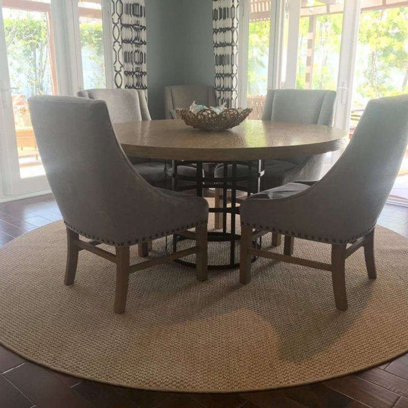 Circle natural grass rug with table and chairs.