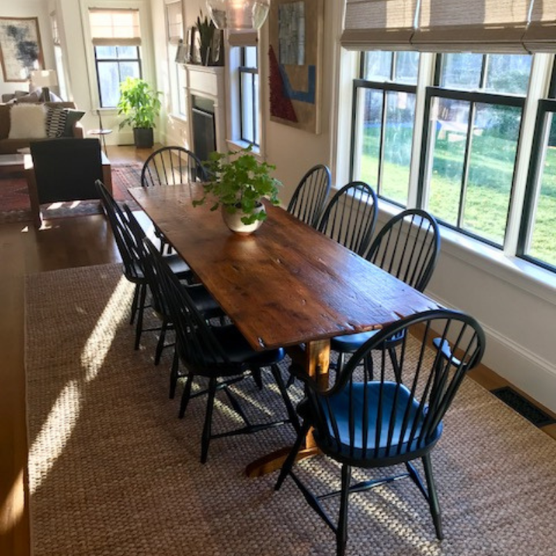 Natural jute area rug with table and black chairs.