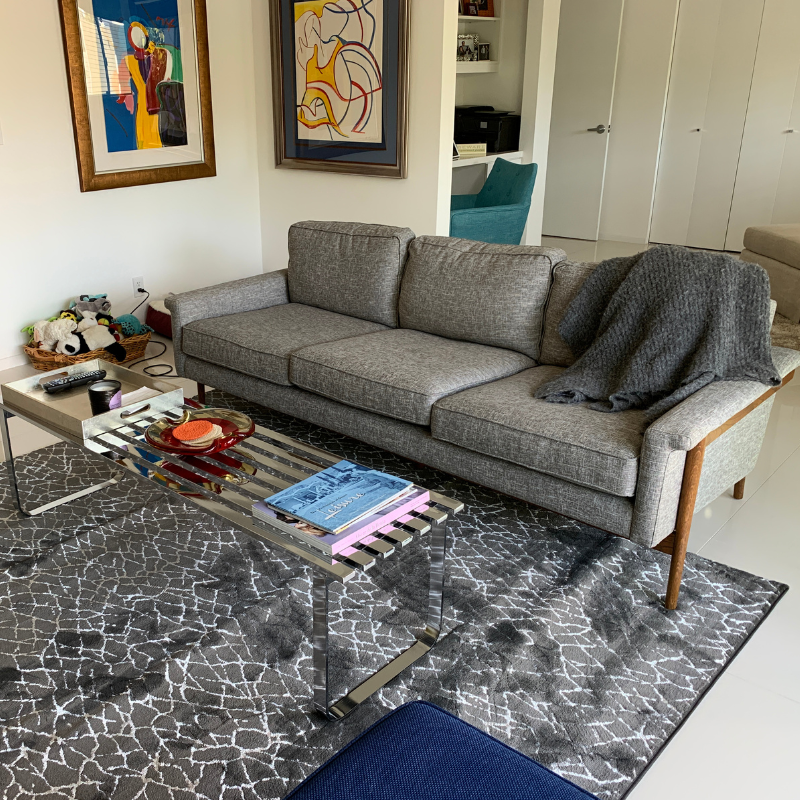 grey and white area rug with grey couch and coffee table.