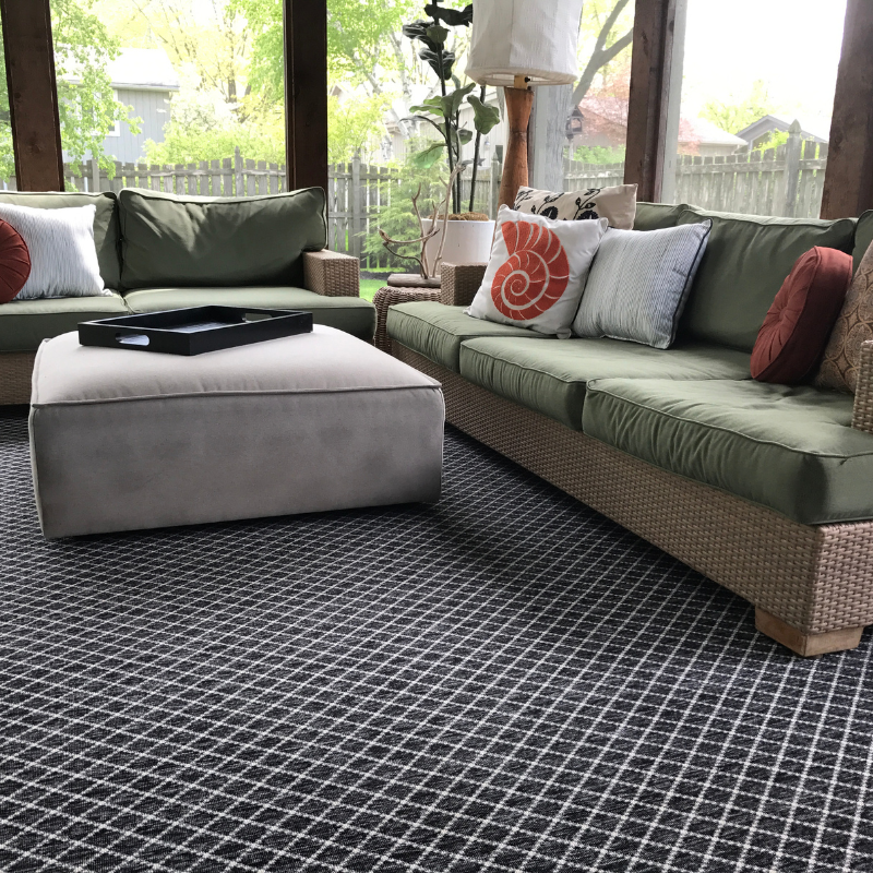 Blue and white striped area rug with green couch.
